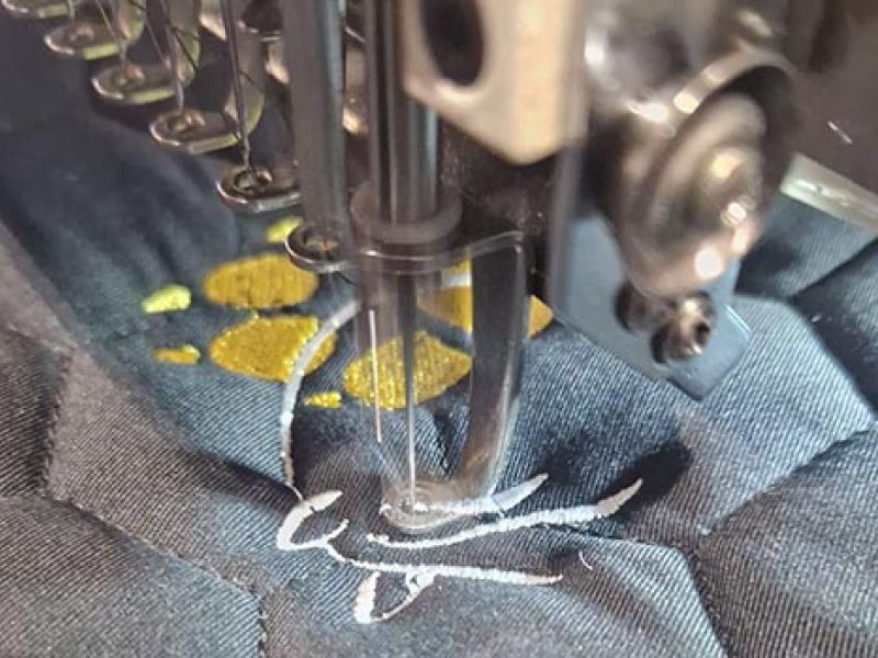 Machine à broder réalisant une broderie personnalisée sur tapis d’équitation – Cap Horse Ornex
